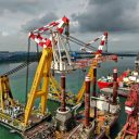 Cranes lifting a crane aboard Bold Tern in Singapore